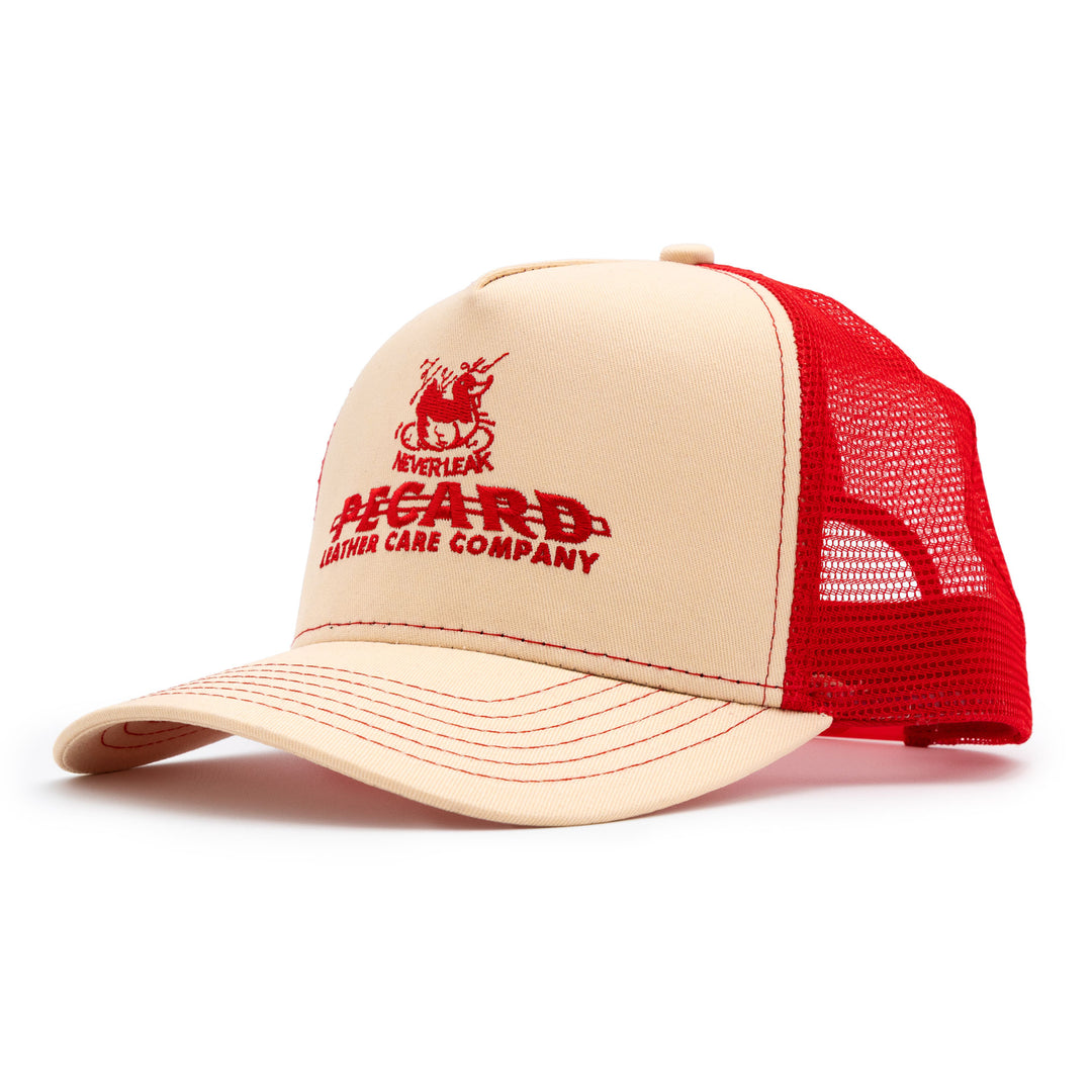 Front-facing view of a beige and red Pecard Trucker Hat featuring the red Pecard Leather Care Company logo on the cream front panel.
